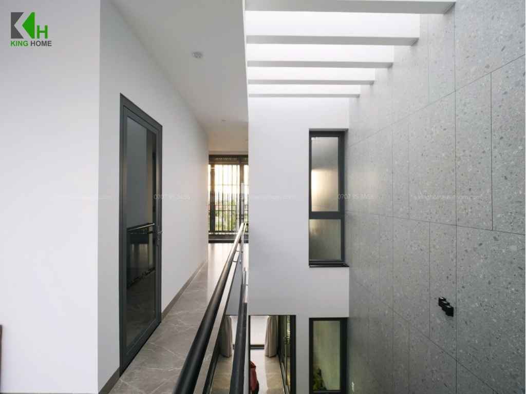 Một điểm nổi bật là phần ô thông tầng được bố trí ngay cạnh cầu thang, tạo khoảng mở theo chiều đứng giúp ánh sáng tự nhiên len sâu vào bên trong nhà.