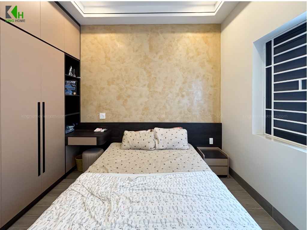 Phòng ngủ thứ hai mang đến cảm giác nhẹ nhàng hơn với mảng tường sơn hiệu ứng màu vàng kem làm điểm nhấn phía sau giường