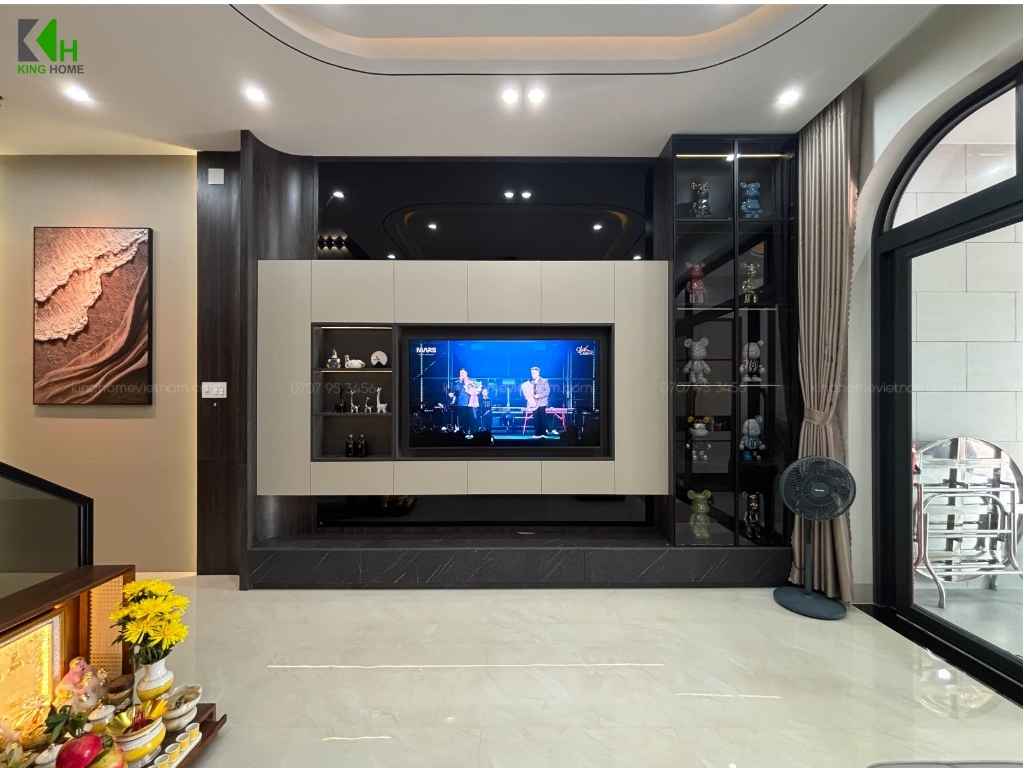 Đối diện là hệ kệ tivi âm tường với các mảng tủ màu trắng và gỗ tối, vừa đáp ứng nhu cầu sử dụng vừa trở thành điểm nhấn trang trí cho căn phòng